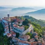 Antica città di Montona in cima alla montagna. La città è circondata da un muro di fortezza. L'immagine di sfondo sono le montagne e la nebbia ai piedi delle montagne. Istria, Croazia. La vista dal drone.