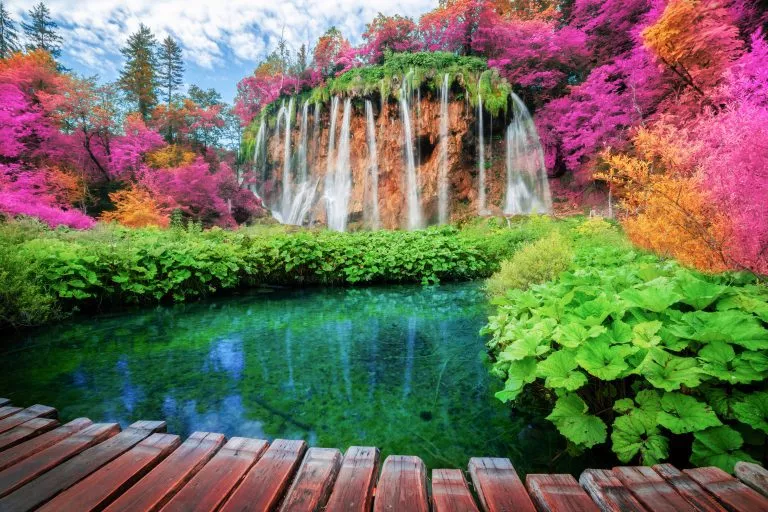 Bellissimo sentiero in legno per il trekking naturalistico con paesaggi di laghi e cascate nel Parco Nazionale dei Laghi di Plitvice, patrimonio naturale dell'UNESCO e famosa destinazione turistica della Croazia.