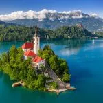 Bled, Slovenia - Aerial view of beautiful Lake Bled (Blejsko Jezero) with the Pilgrimage Church of the Assumption of Maria on a small island and Bled Castle and Julian Alps at backgroud at summer time